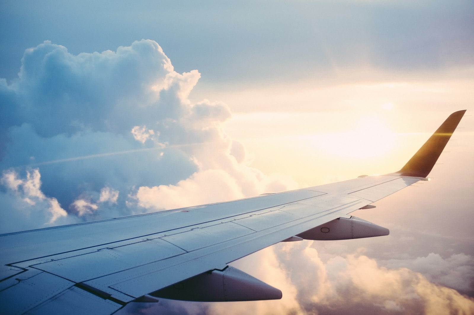 Aircraft wing above the clouds — curated air travel